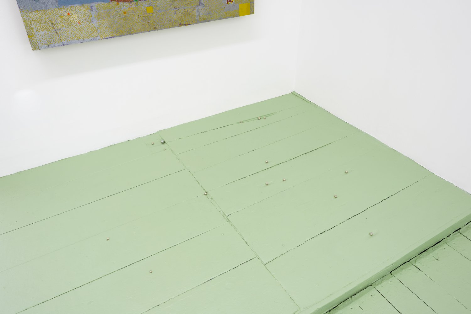 A close up of a wood floor painted light green